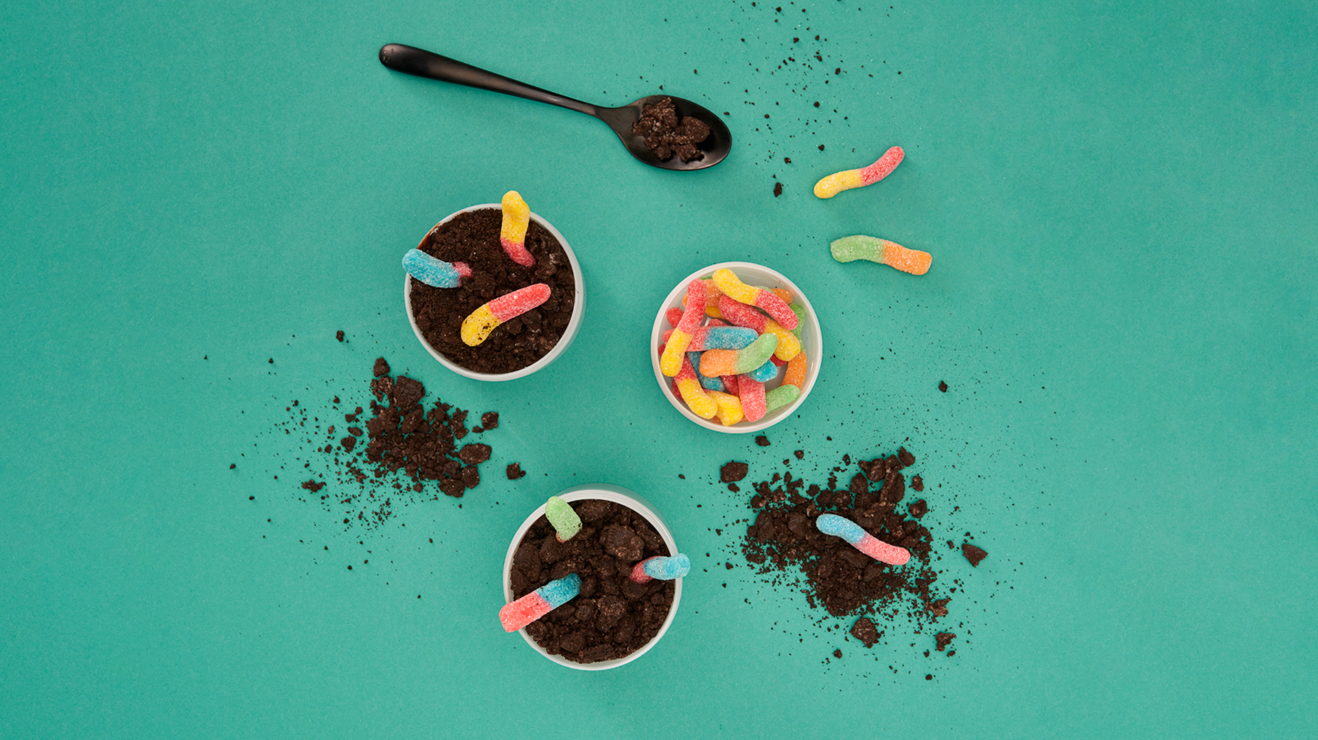 A display of dirt cups on a teal background.