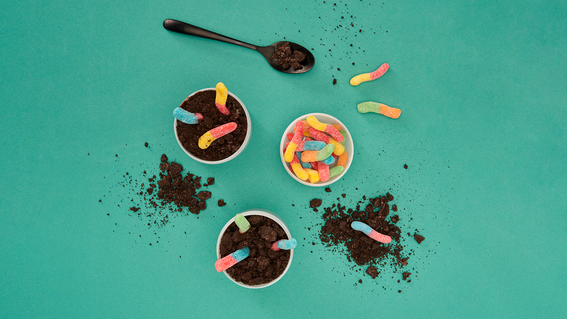 A display of dirt cups on a teal background.