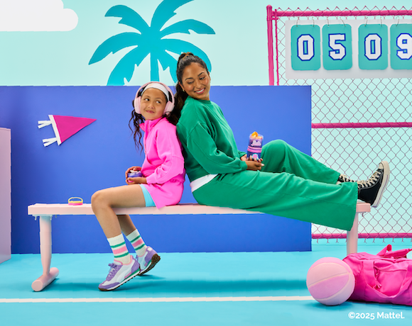 Two people sitting on a bench in a colorful indoor playground setting.