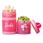 Two pink snack containers with Barbie logo, one filled with popcorn and the other with cucumbers.